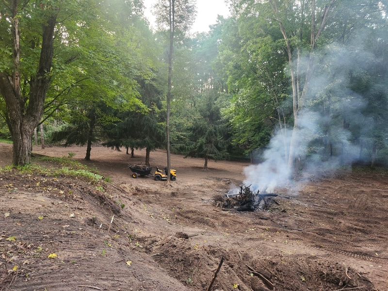 Brush clearing project with debris burn pile on a cleared wooded property in Holmen, Wisconsin